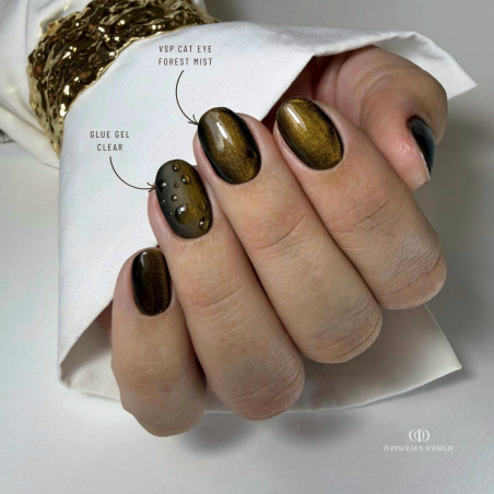 Pose d'ongles ovales avec le vernis semi permanent Cat  Eye Forest Mist, marron noir aux reflets dorés
